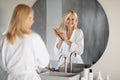 Smiling Mature Woman Brushing Her Hair With Comb Near Mirror In Bathroom Royalty Free Stock Photo