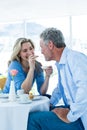 Smiling mature woman feeding food to man Royalty Free Stock Photo