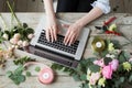 Smiling Mature Woman Florist Small Business Flower Shop Owner. She is using her telephone and laptop to take orders for Royalty Free Stock Photo