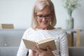Smiling mature woman in glasses reading book close up Royalty Free Stock Photo