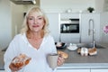 Smiling mature woman holding cupcake and cup of coffee Royalty Free Stock Photo