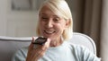 Smiling mature woman holding smartphone, recording voice message Royalty Free Stock Photo