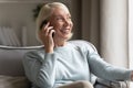 Smiling mature woman look in distance talking on cell Royalty Free Stock Photo