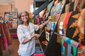 Smiling mature woman looking at colorful fabric in her shop Royalty Free Stock Photo