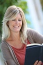 Smiling mature woman reading book Royalty Free Stock Photo