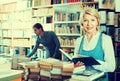 Smiling mature woman reading book in book shop Royalty Free Stock Photo