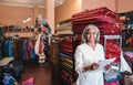 Smiling mature woman reading paperwork in her fabric shop Royalty Free Stock Photo
