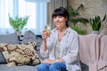 Smiling mature woman relaxing at home with glass of lemon water Royalty Free Stock Photo