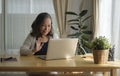 Smiling mature woman sitting in bright living room and having video call on computer laptop Royalty Free Stock Photo