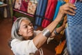 Smiling woman looking at cloth rolls in a fabric shop Royalty Free Stock Photo