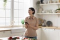 Smiling mature woman using modern smartphone in the kitchen Royalty Free Stock Photo