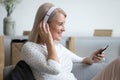 Smiling mature woman in headphones enjoying music, using phone Royalty Free Stock Photo