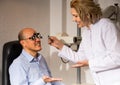 Mature woman and man retired ophthalmologist check eyesight in clinic