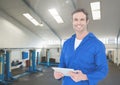 Smiling mechanic holding digital tablet in garage Royalty Free Stock Photo