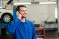 Smiling mechanic on the phone Royalty Free Stock Photo