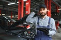 Smiling mechanic using a tablet pc at the repair garage. Royalty Free Stock Photo