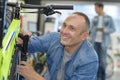 Smiling mechanic working on bicycle shock absorbers Royalty Free Stock Photo