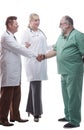 Smiling medical colleagues greeting each other with a handshake.