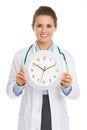 Smiling medical doctor woman showing clock Royalty Free Stock Photo