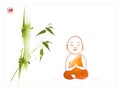 Smiling and meditating buddhist monk in orange robe under the green bamboo tree. Translation of hieroglyph - zen