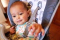 Smiling messy baby after eating chicken with broccoli