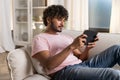 A smiling mestizo guy reclining on the sofa in the room, enjoys relax after work or study in the cozy home environment Royalty Free Stock Photo