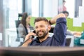 Smiling mid adult businessman talking on telephone in office Royalty Free Stock Photo