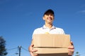 Smiling mid adult deliveryman carrying box with products