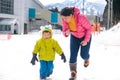 Smiling middle age Asian Mother and cute smiling little 2-3 years old toddler boy child playing happily in snow Royalty Free Stock Photo