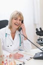 Smiling middle age doctor woman speaking phone Royalty Free Stock Photo