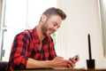 Smiling middle age man sitting at desk with cellphone Royalty Free Stock Photo