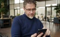 Middle age man using phone in restaurant or cafe Royalty Free Stock Photo