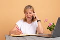 Smiling middle age woman talking on phone, sitting at home, attractive female holding smartphone, making or answering Royalty Free Stock Photo