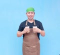 A smiling middle-aged barista holding a cup of coffee to-go in each hand. Isolated on a blue background Royalty Free Stock Photo