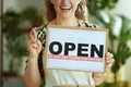 Smiling middle aged business owner woman showing open sign Royalty Free Stock Photo