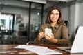 Smiling middle aged business woman using cell phone working in office. Portrait Royalty Free Stock Photo