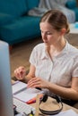 Smiling middle-aged businesswoman in glasses and headset working on laptop in office talk with colleague, happy Royalty Free Stock Photo