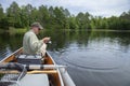 Smiling middle aged fisherman reels in a walleye on a lake in northern Minnesota Royalty Free Stock Photo