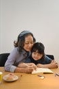 Smiling middle aged grandma and little preschooler granddaughter drawing together at home