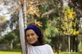 Smiling middle aged lady holds swing chain in the park