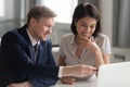 Smiling middle aged team leader helping korean female happy intern. Royalty Free Stock Photo