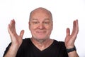 Smiling Middle-Aged Man in Black T-Shirt with Hands Raised on White Background - Happy Lifestyle Concept Royalty Free Stock Photo