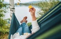 Smiling middle-aged man dressed in warm knitted clothes and jeans lying in the cozy car trunk and enjoying the mountain lake view Royalty Free Stock Photo