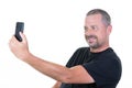 Smiling middle aged man making selfie photo on smartphone isolated on white background Royalty Free Stock Photo