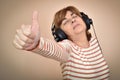 Woman with headphones showing thumb up