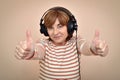 Woman with headphones showing thumbs up