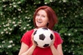 Smiling middle-aged woman standing with football ball outdoors. Active lifestyle Royalty Free Stock Photo
