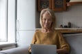 Smiling older woman using laptop at home Royalty Free Stock Photo