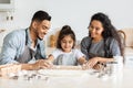 Smiling middle-eastern family parents and kid making biscuits at home Royalty Free Stock Photo