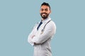Middle-Eastern Male Doctor Posing Crossing Hands Over Blue Background Royalty Free Stock Photo